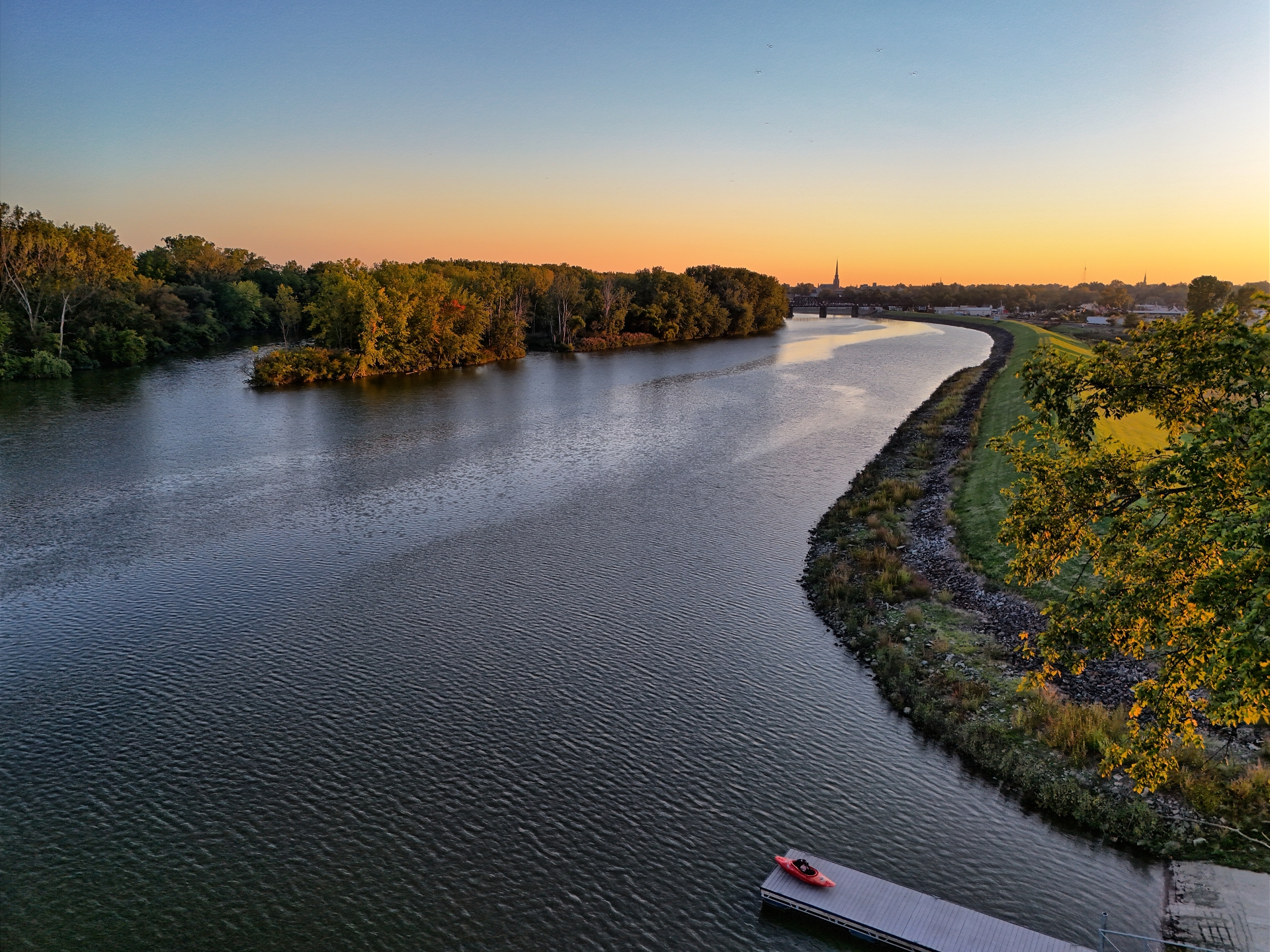 An aerial view of a river captured with a drone at sunset.