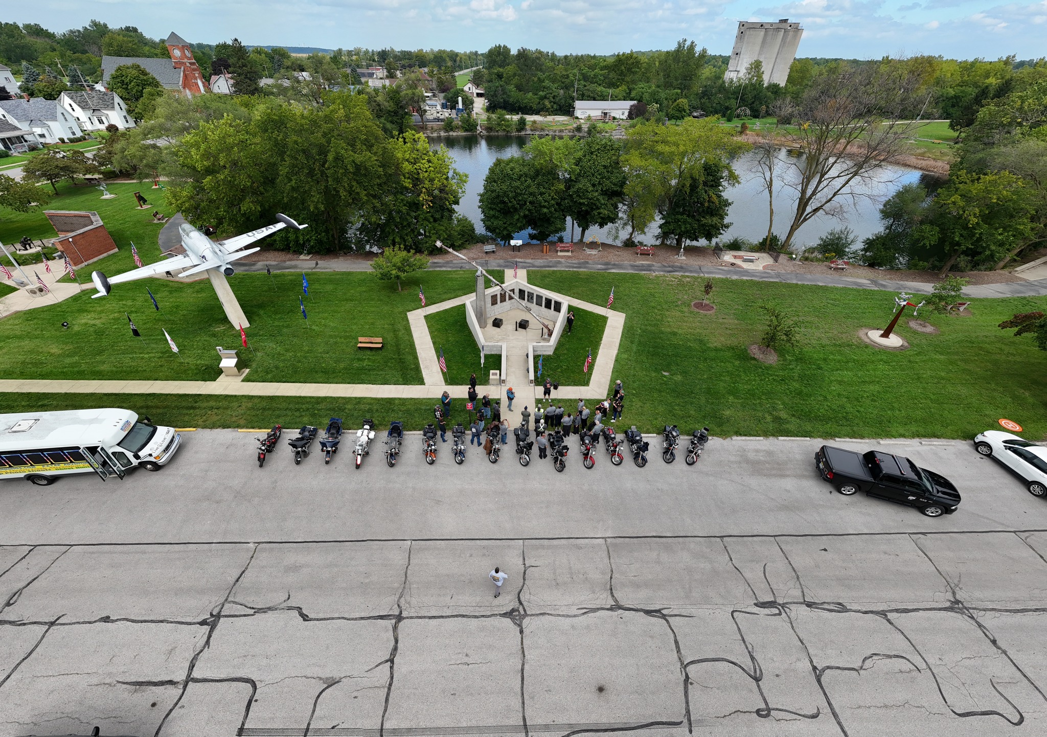 A crowd of people gathered in front of a bus during a motorbike event.