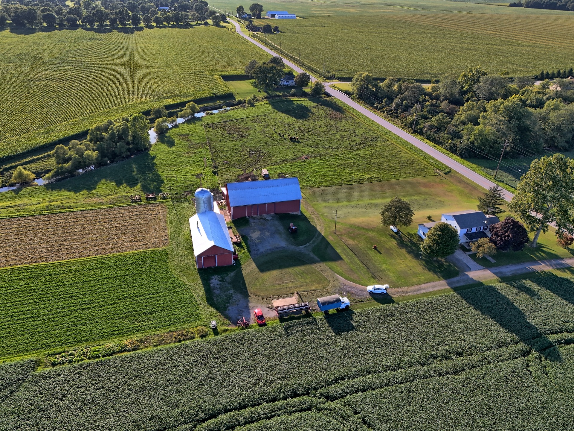 Residential farm and barn captured from aerial perspective.