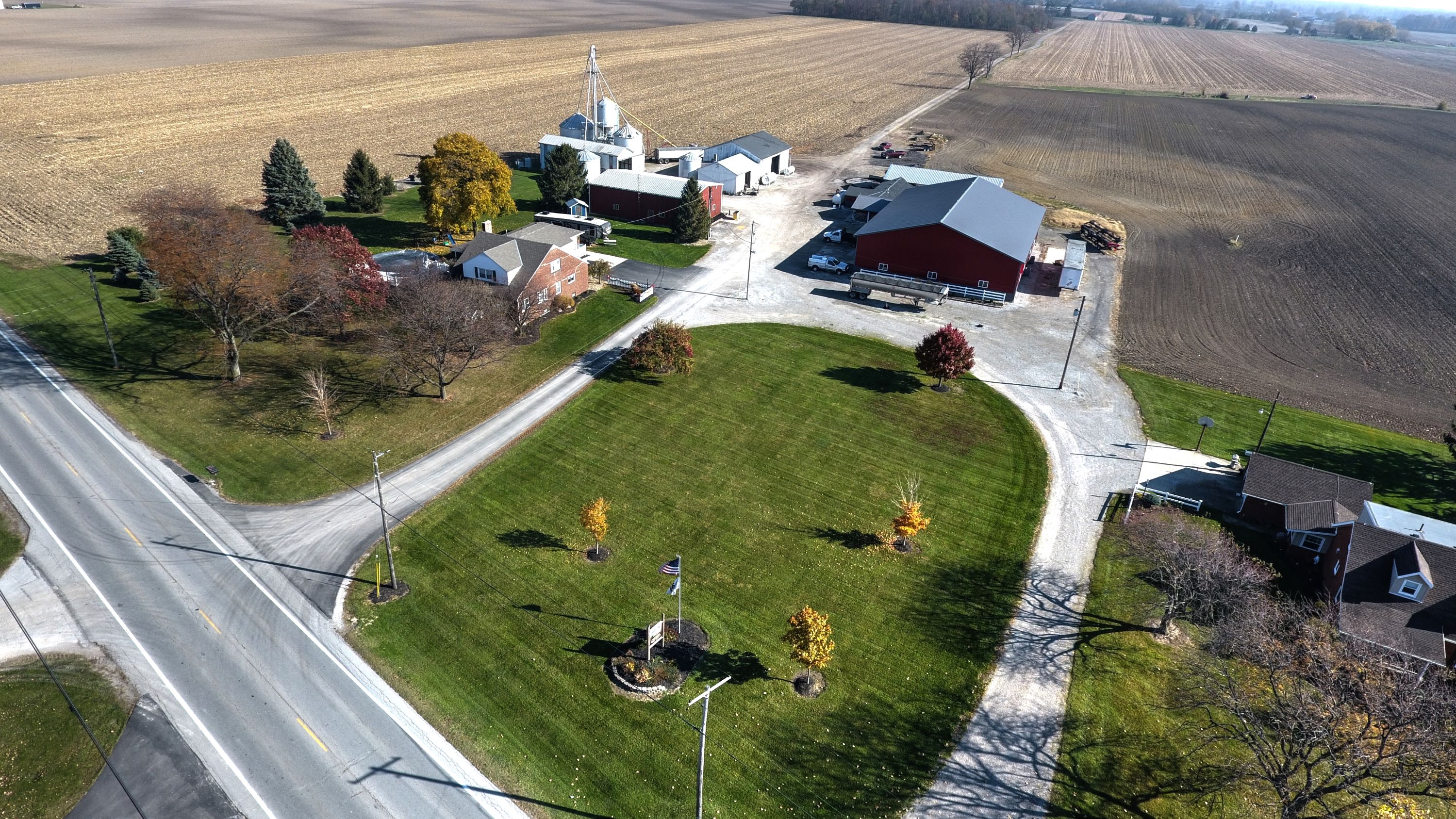 Aerial view of a residential house and church in a serene rural area.